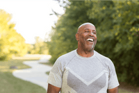 Older man smiling outdoors in a green park, lifestyle for UMF 28+ MGO 1450+ Manuka honey