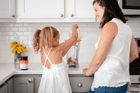 Mother and daughter making a smoothie in a bright kitchen, UMF 10+ MGO 263+ Manuka honey on the counter