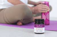 UMF 24+ MGO 1122+ Manuka honey jar on a yoga mat with water bottle, post-workout scene