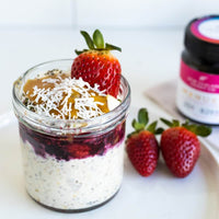 Overnight oats topped with berries and honey beside a UMF 20+ MGO 829+ Manuka honey jar