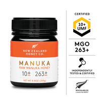 Honey dripping from a wooden dipper into a glass bowl, UMF 10+ MGO 263+ Manuka honey