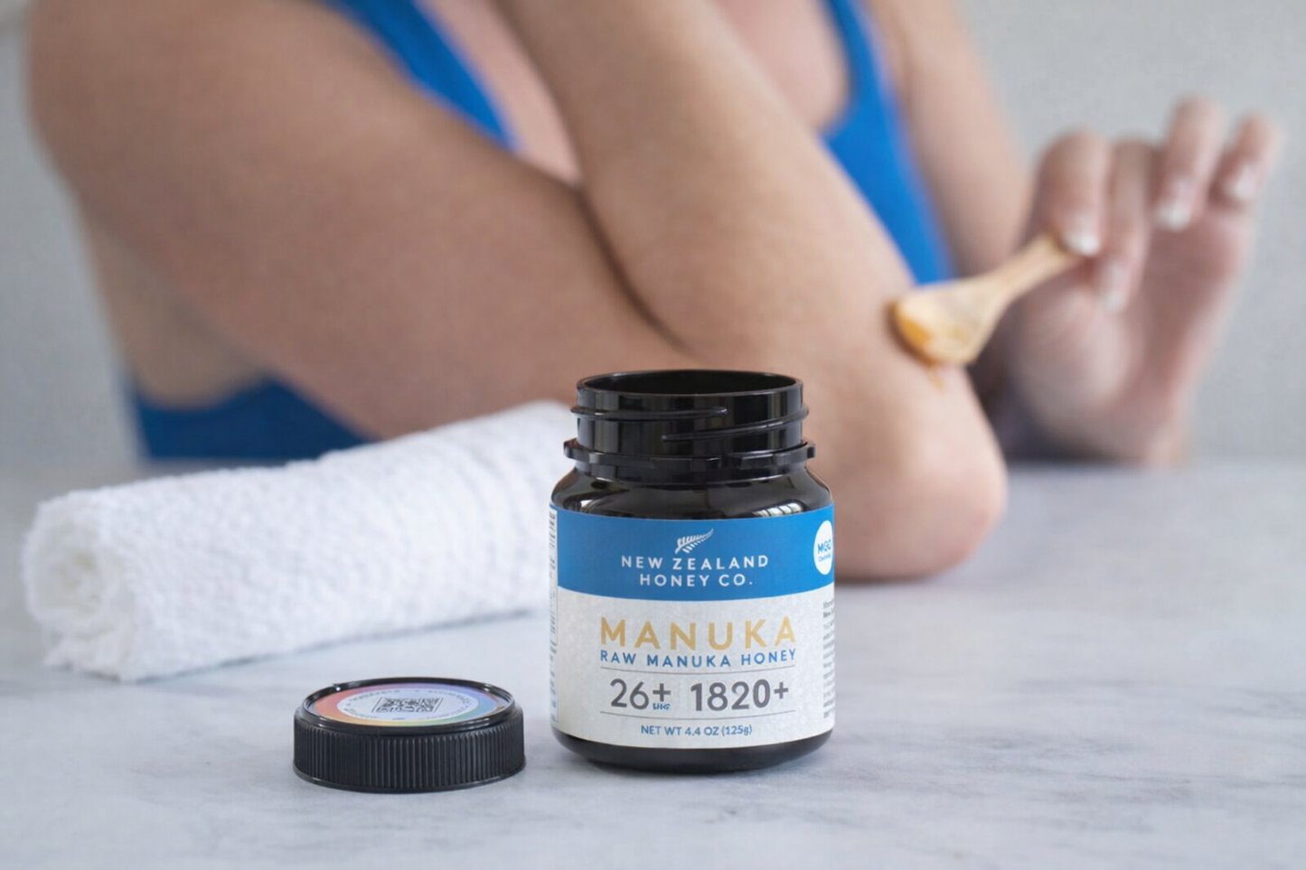 UMF 26+ MGO 1282+ Manuka honey mini jar beside a bowl, towel and feet at a spa