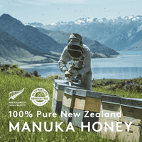 Beekeeper at hives by a New Zealand lake, source of UMF 24+ MGO 1122+ Manuka honey