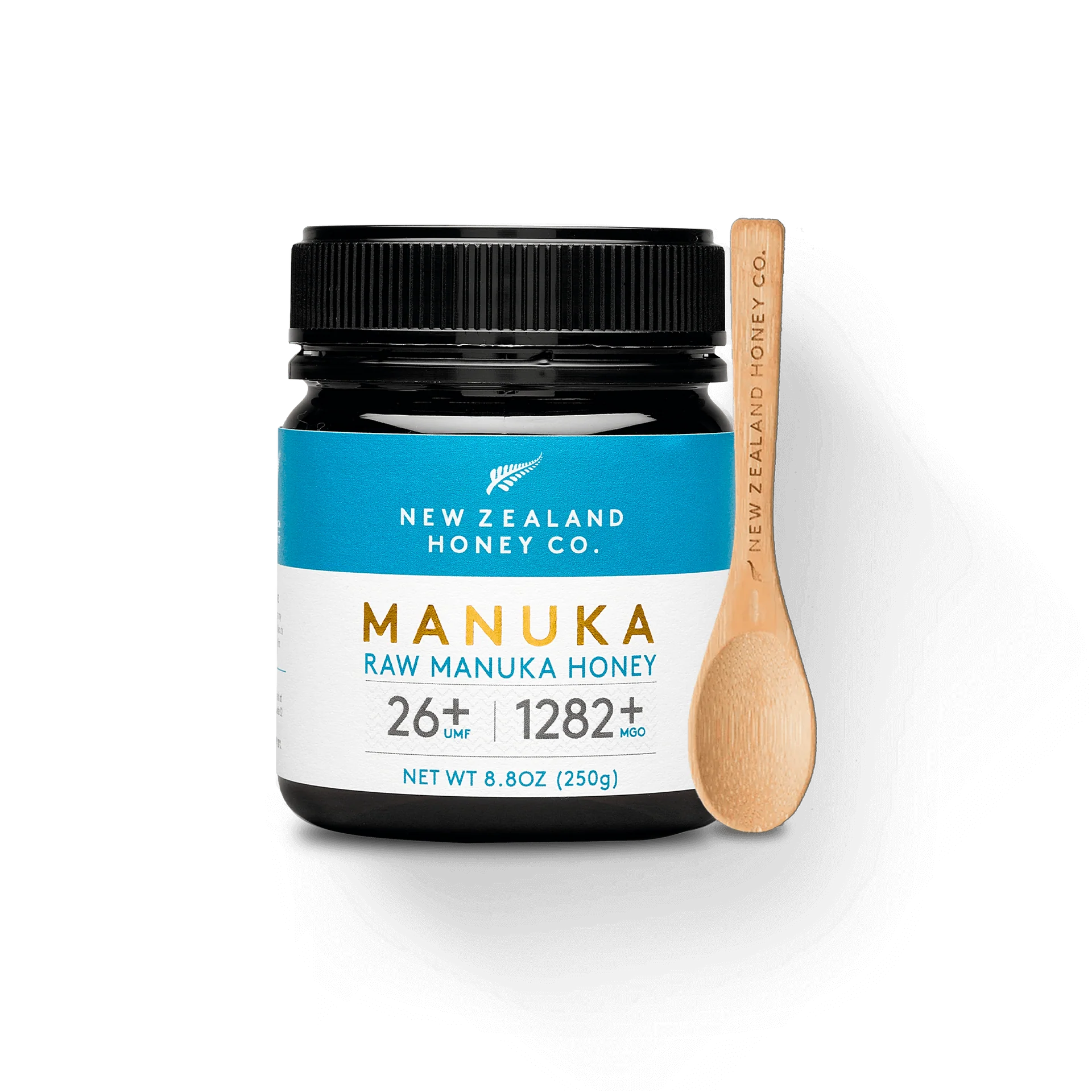 UMF 26+ MGO 1282+ Manuka honey 250g jar with bamboo spoon on black background