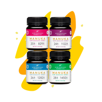 Four Manuka Honey Minis jars (UMF 20+, 24+, 26+, 28+) on yellow splash background